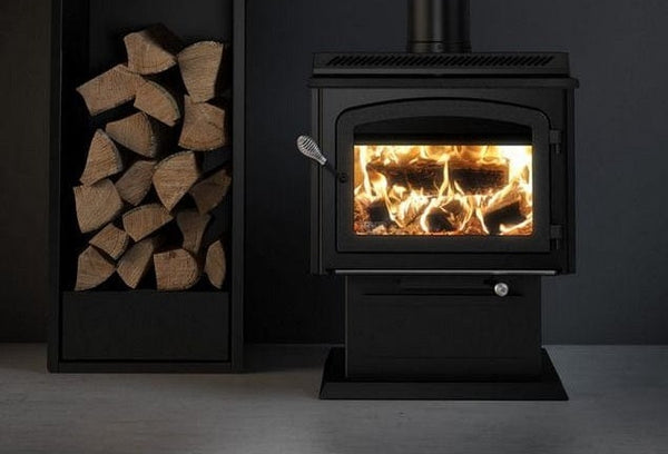 Drolet HT3000 wood stove burning beside a log rack