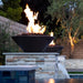 The Outdoor Plus Cazo Concrete Fire Bowl in a garden setting