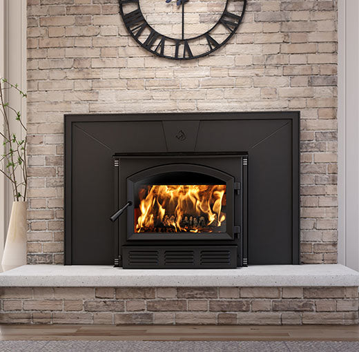 Close view of the Enerzone Solution 3.5 wood insert arched glass door and lower louver panel with a fire burning
